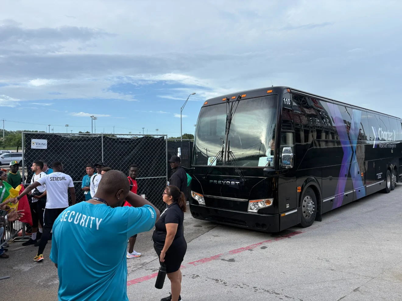 ETI crew and passengers alongside a CharterX-branded coach during real transportation operations